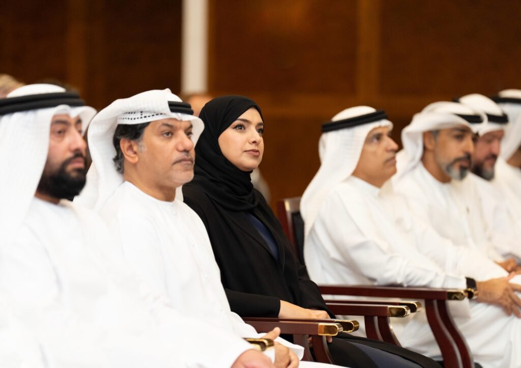 A group of professionals seated at an event focused on environmental sustainability, with Her Excellency Dr. Amna bint Abdullah Al Dahak prominently featured, attentively listening.