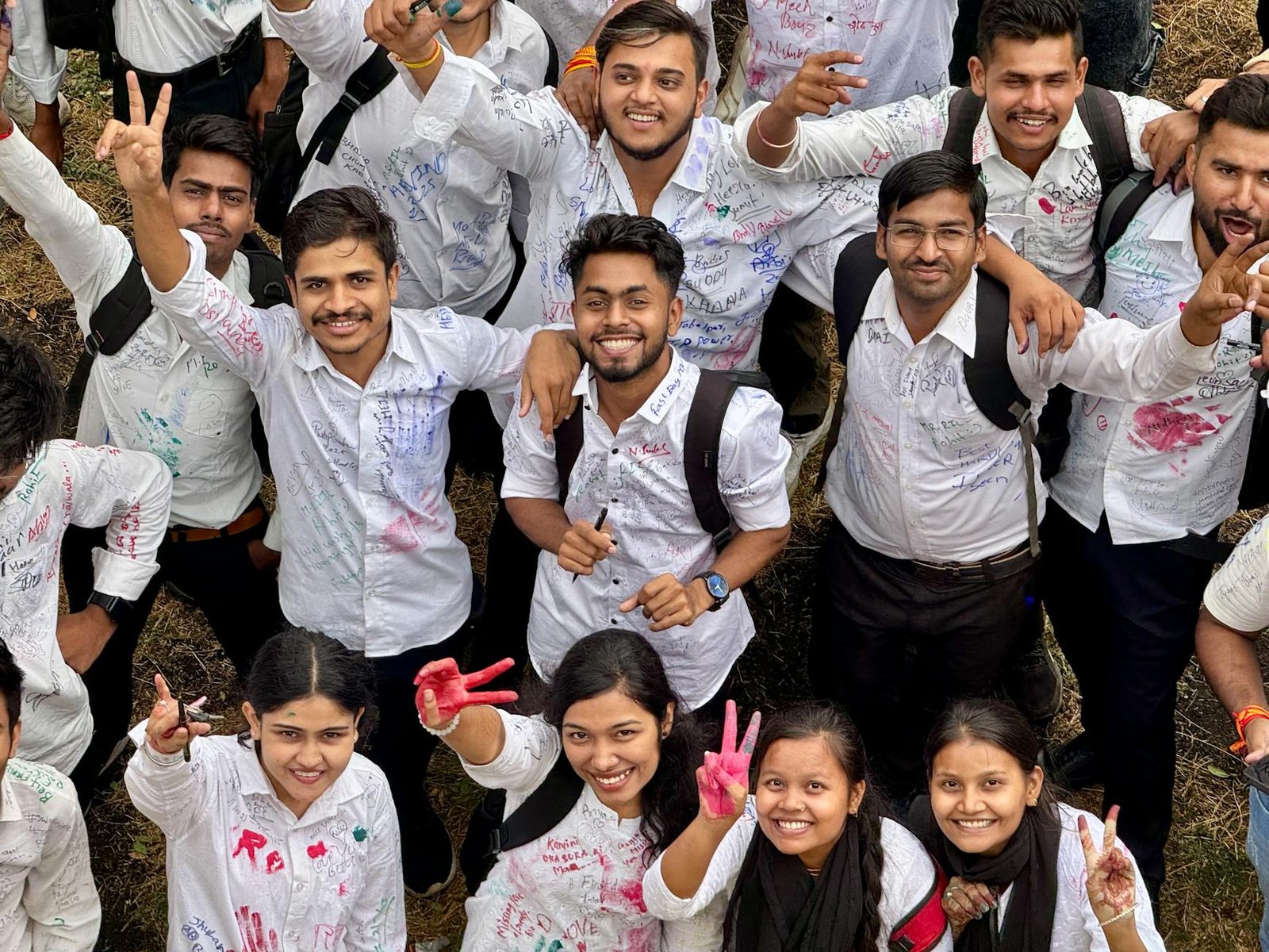 group of happy students celebrating together outdoors