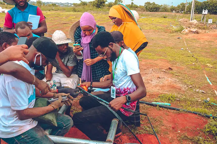 A group of individuals learning about irrigation and soilless farming techniques in an outdoor setting, with one person demonstrating the use of tools.As climate change threatens food security, one innovative farmer in Africa has a radical solution: stop using soil altogether. Samson Ogbole is proving that the future of African agriculture might not be in its earth, but in its air.

Known professionally as Farmer Samson, he leads Soilless Farm Lab in Nigeria, where he's combining artificial intelligence with aeroponic farming to grow food year-round. His approach is challenging fundamental assumptions about how Africa feeds itself.