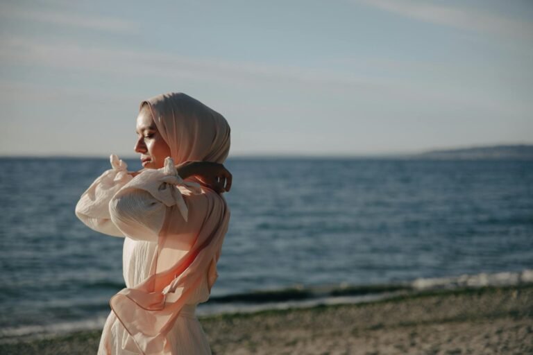 a woman wearing a hijab at the beach