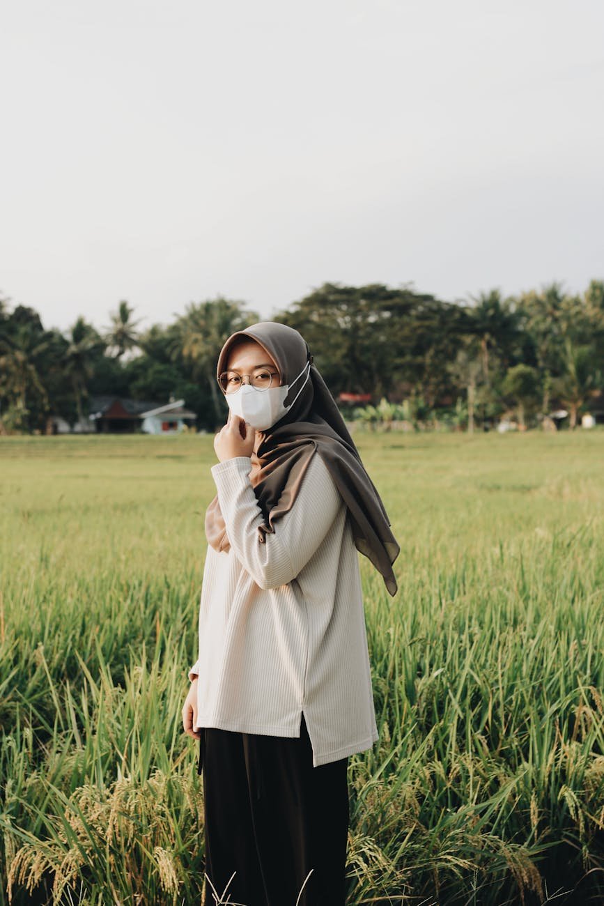a woman wearing a face mask on a field