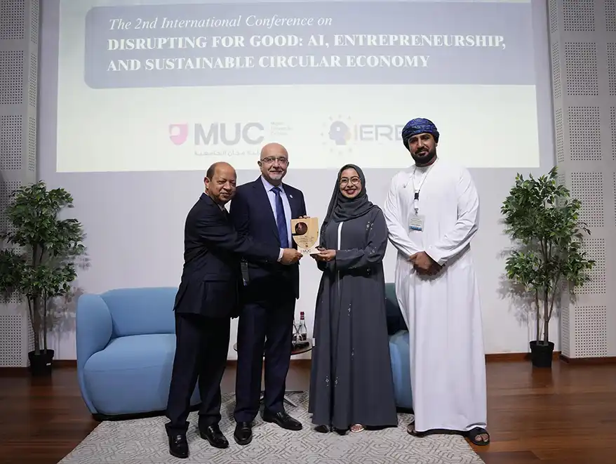 Four individuals at the 2nd International Conference on Disrupting for Good, showcasing a plaque presented to a female speaker, with a backdrop of the conference title.