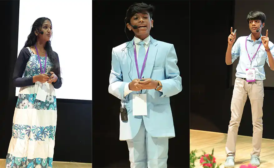 A young girl in a patterned dress delivers a speech on stage.