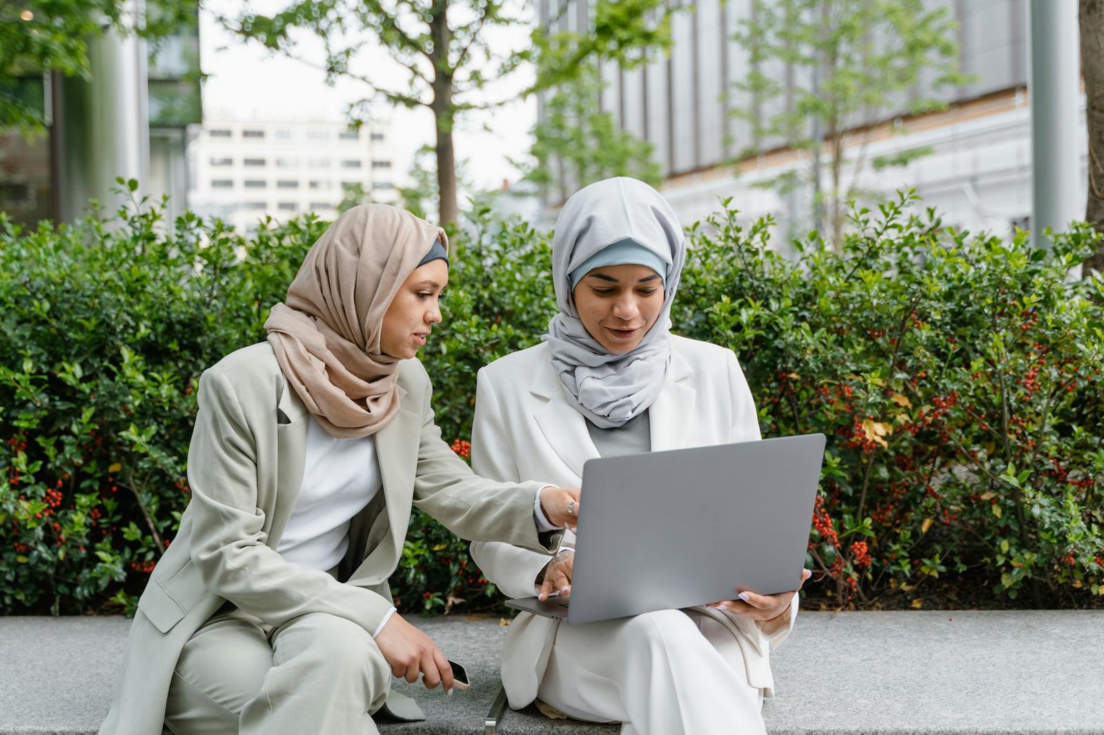 women in business attire using a laptop