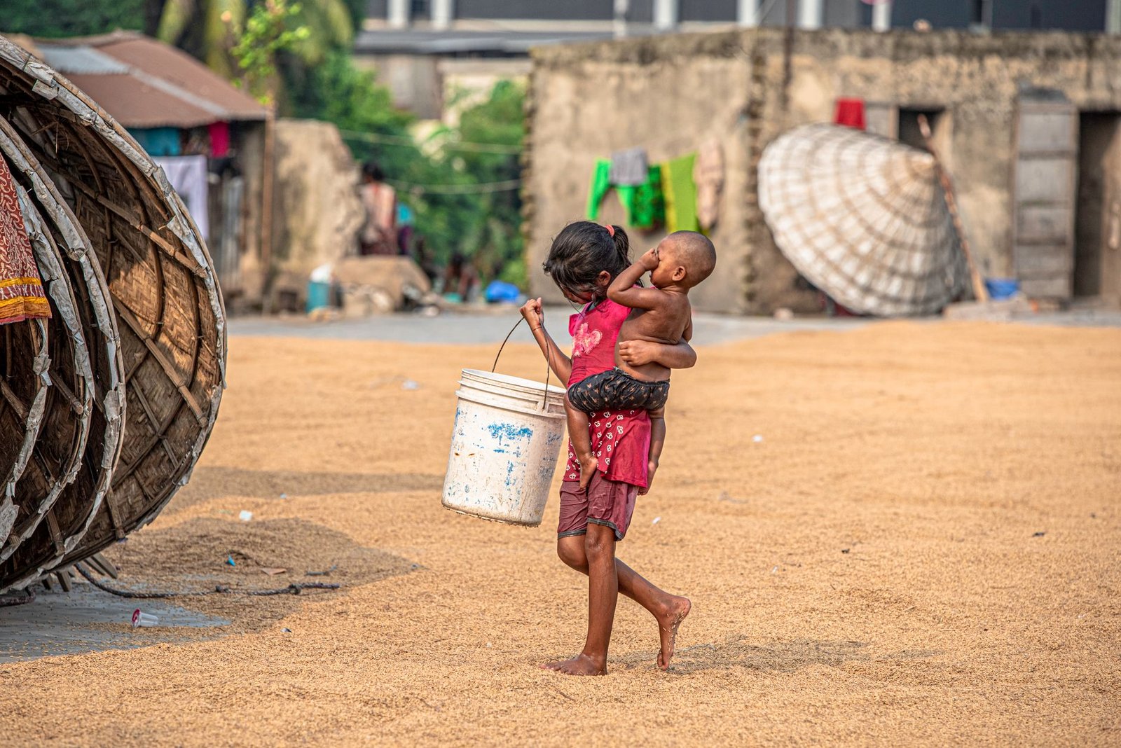 children playing with bucket in rural setting