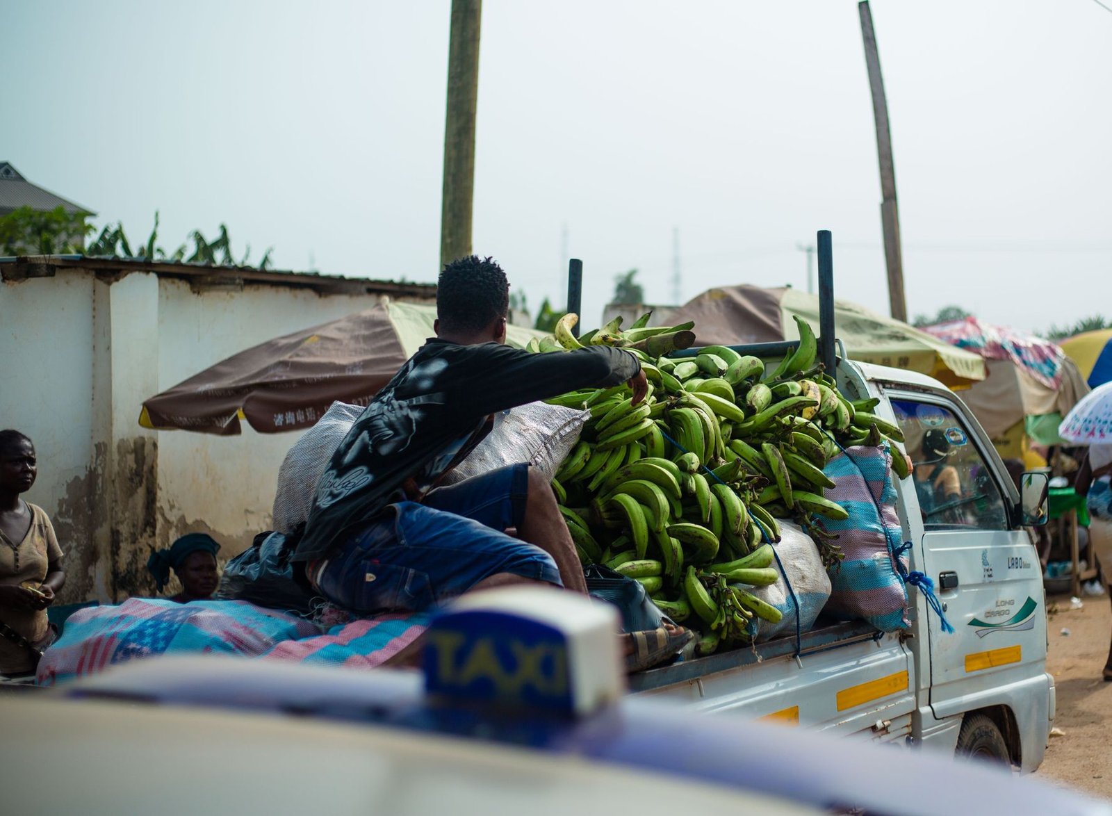 street market scene in accra with plantain truck