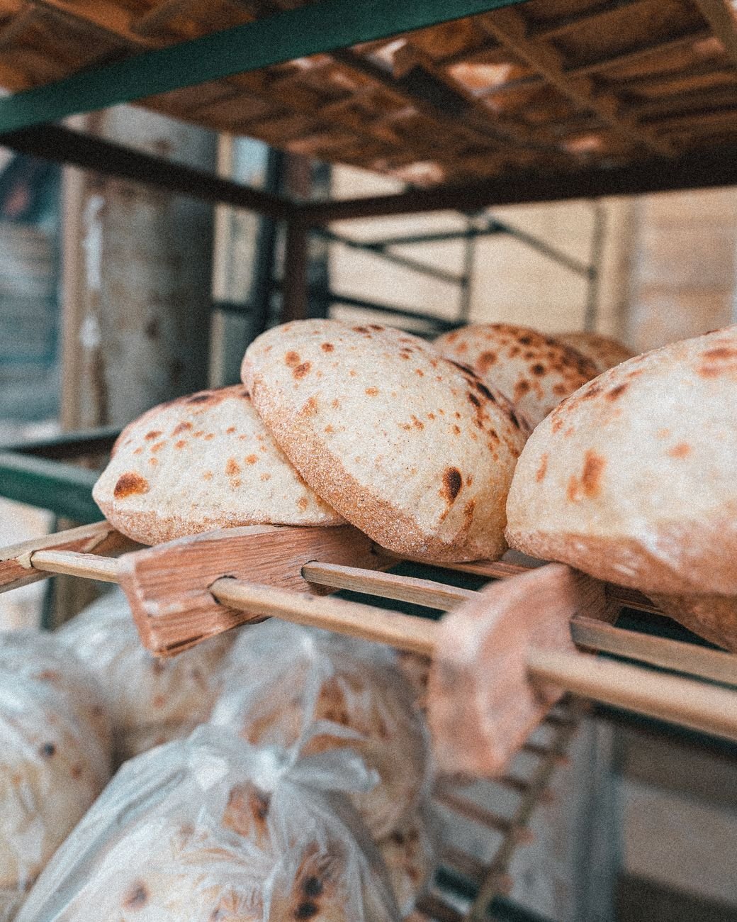 a stock of round bread on a wooden rack