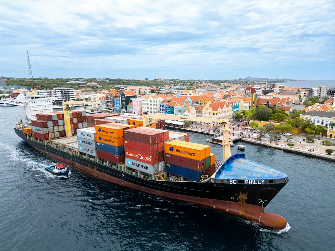 A cargo ship navigates through a Caribbean port
