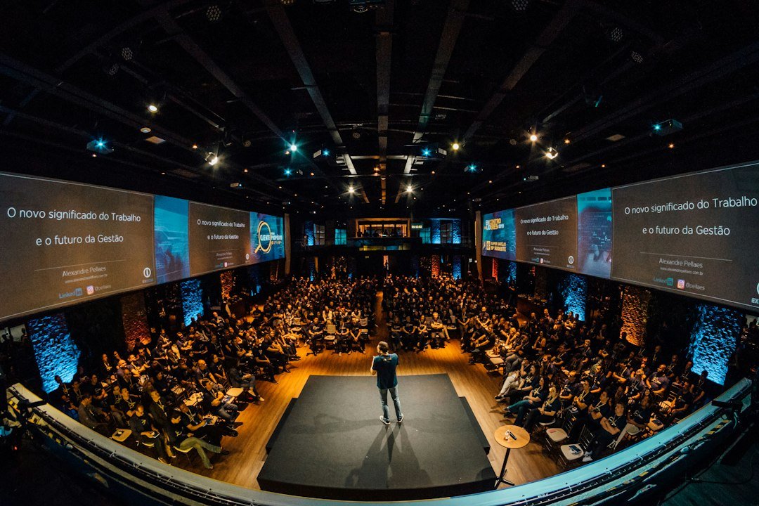 Speaker on stage addressing a large audience