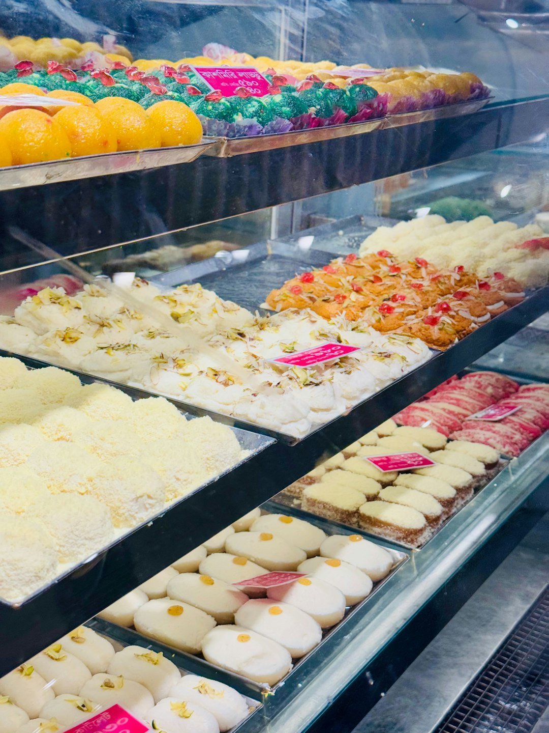 Assortment of colorful Indian sweets displayed in a shop