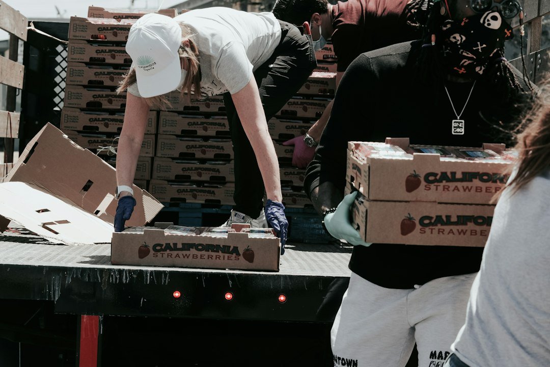 A relief worker carries a food aid box