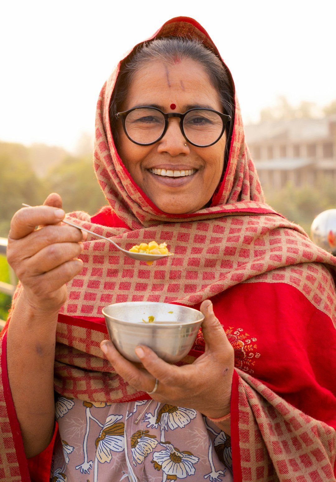 A woman in India holding a bowl of food