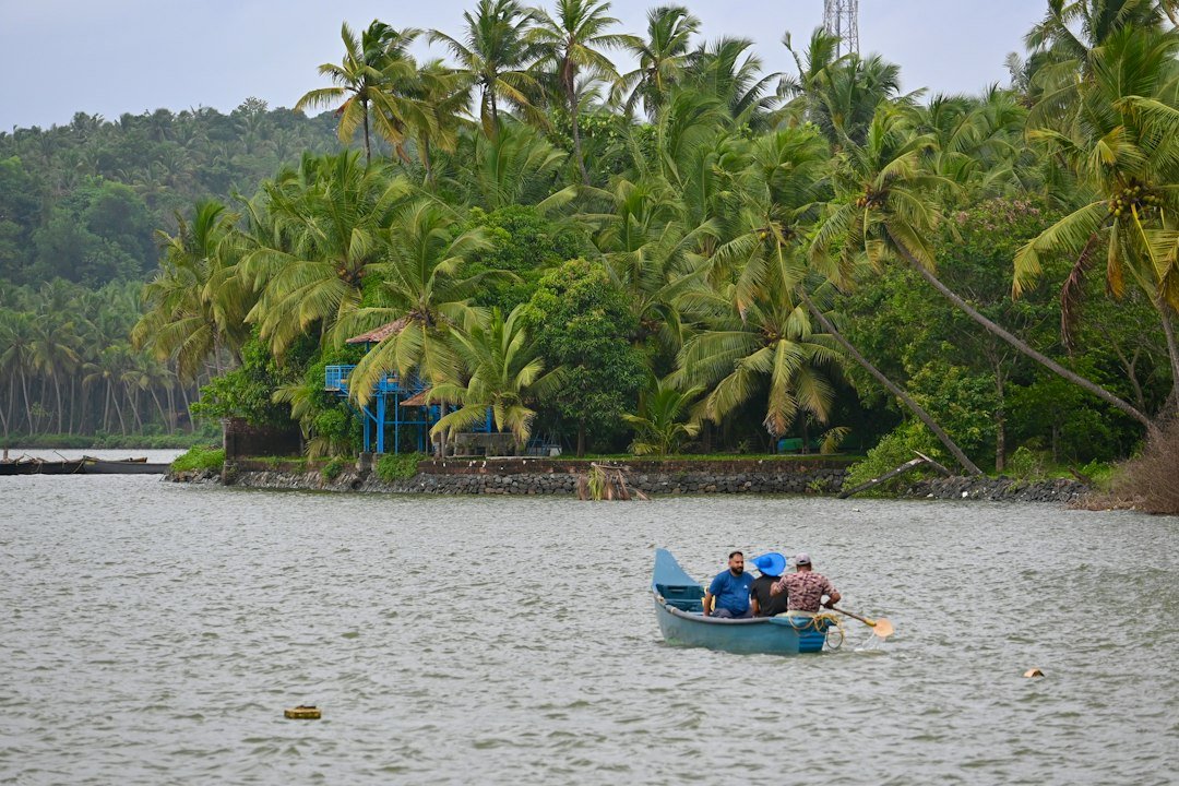 A group of people in a small boat on a lake in Kerala