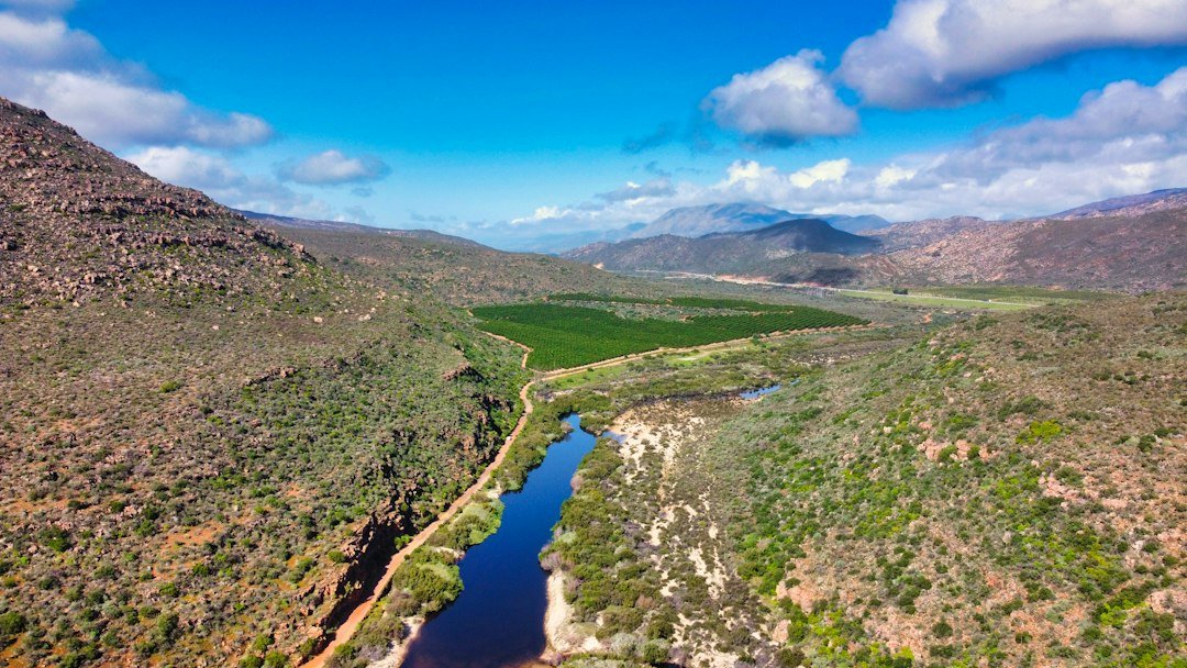 Aerial drone view of a green river valley and farmland in South Africa