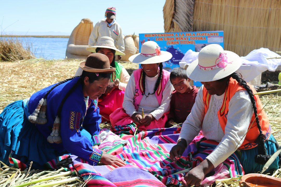 Indigenous people of Peru sitting together on a grass-covered field