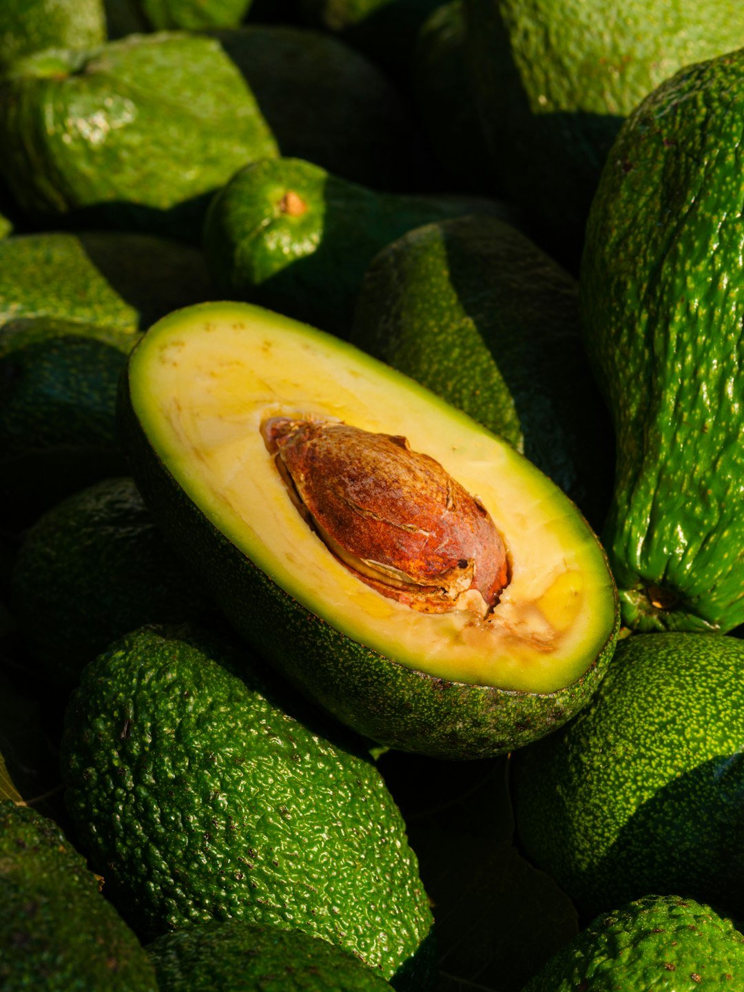A pile of green avocados