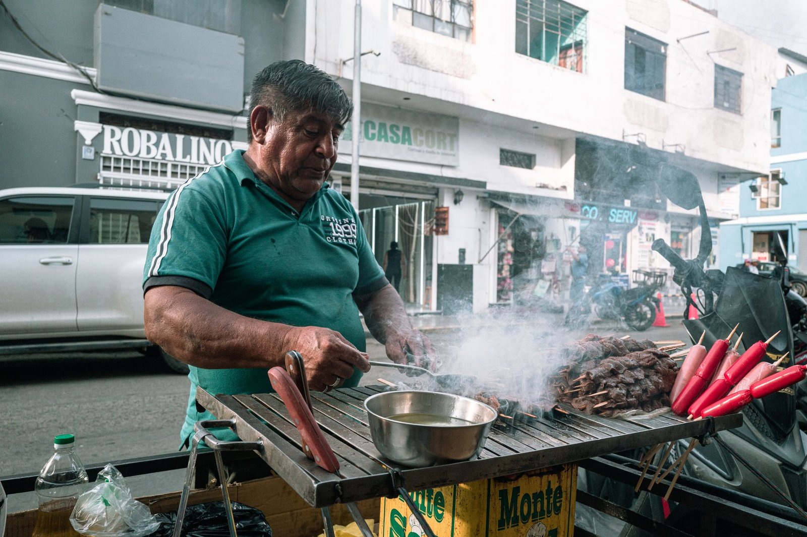 street vendor grilling skewers in urban peruvian setting
