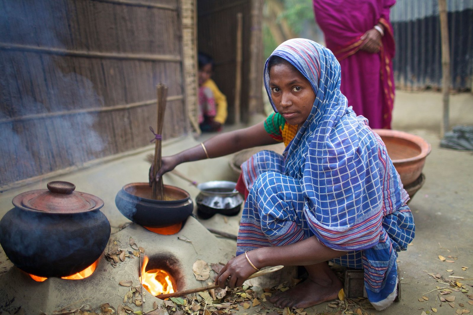 woman cooking with traditional clay stove in bangladesh