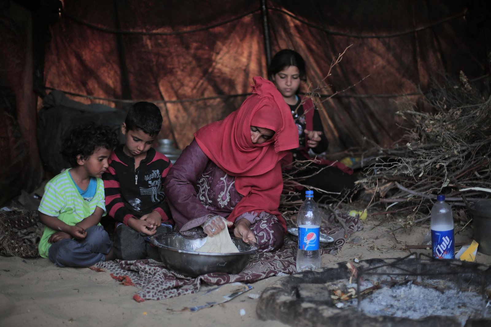 family cooking in rustic tent shelter