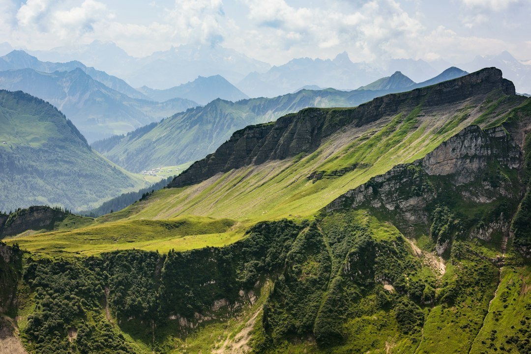 A scenic view of a green mountain range under a cloudy sky
