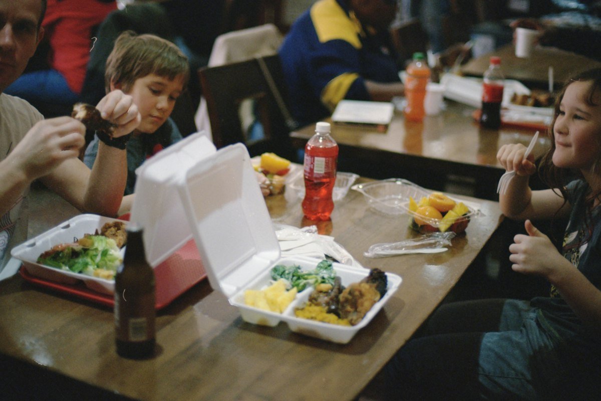 Two children sitting beside a dining table