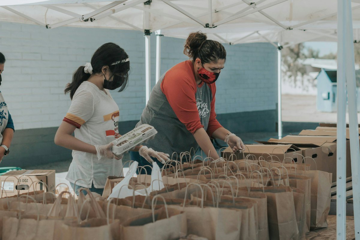 Women packing food aid bags at a distribution point