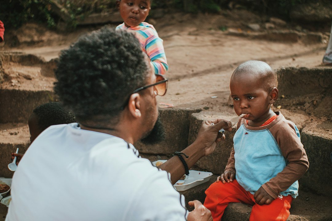 A man giving a young child something to eat