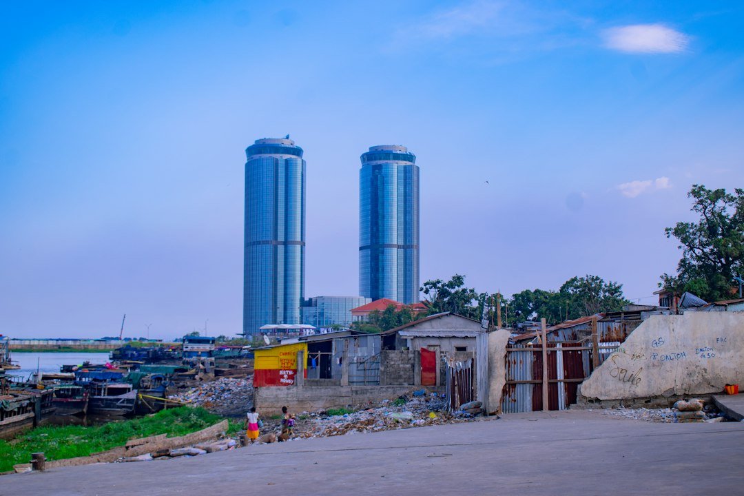 Two tall cylindrical grain silos stand behind a village