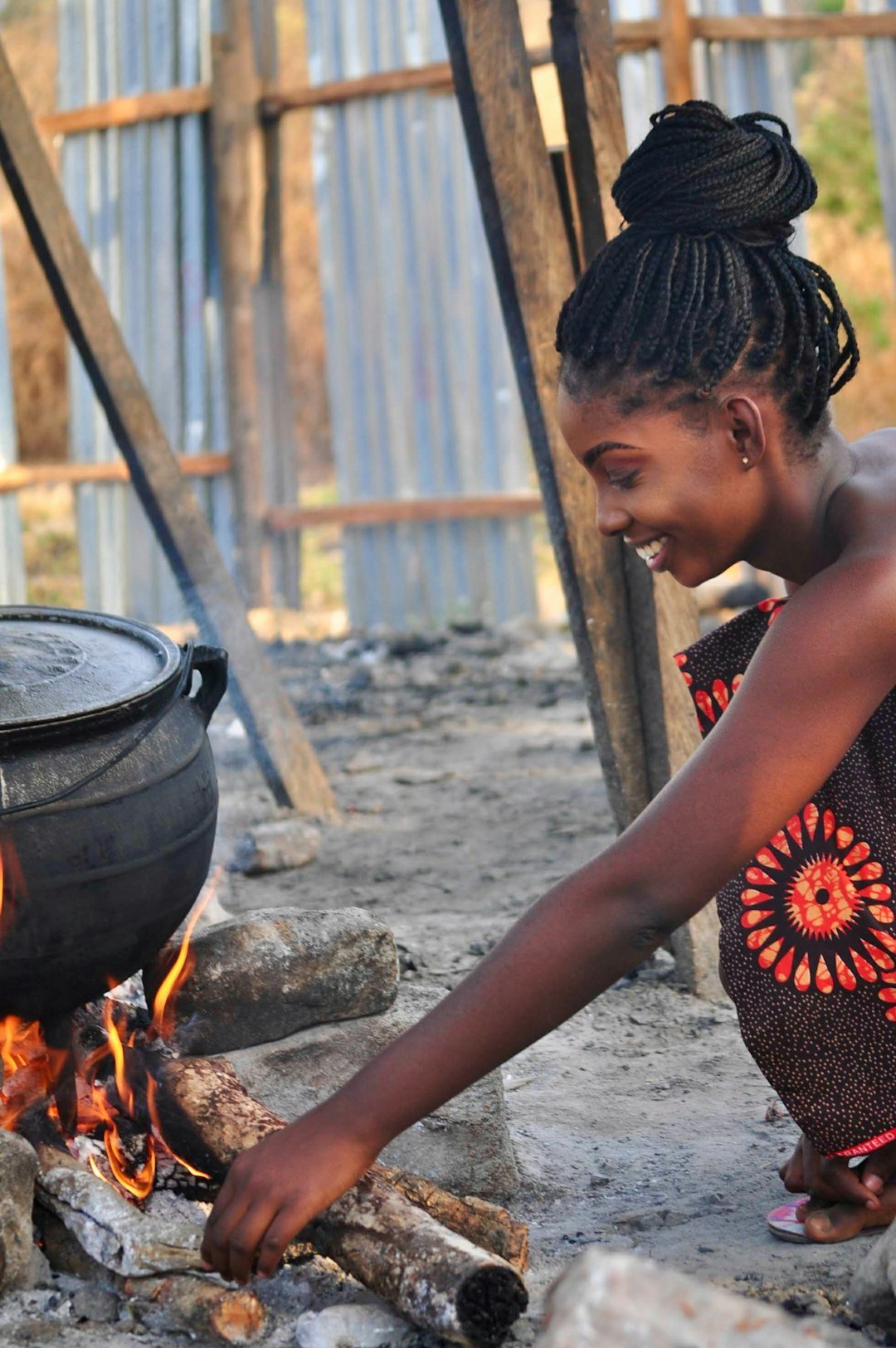 A woman cooking traditional food over an open fire outdoors